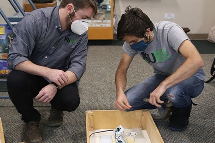 Students installing lighting fixtures in the geology lab